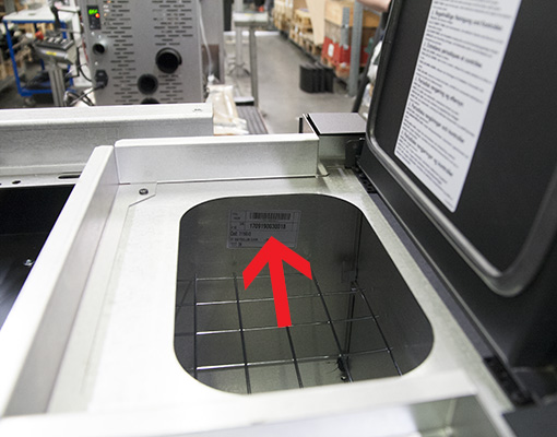 Geöffneter Pelletbehälter eines MCZ-Ofens mit rotem Pfeil auf das Typenschild